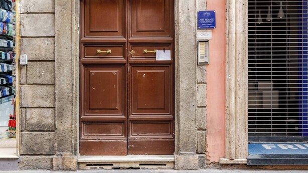 A historic building entrance with a large wooden double door, a stone archway above, and a sign indicating the name 'Loris Dehiscence Viris Honestis'. - ***Newly Restored*** Spanish Steps Cosy apartment (Roma)