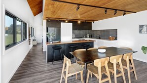 Une cuisine moderne dotée d’un grand îlot central, de chaises en bois et d’une table à manger.