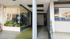 A building entrance with a glass door, a small outdoor area with potted plants, and a staircase leading inside. - Elegant Stays at Vanasthalipuram Hyderabad (Hyderabad)