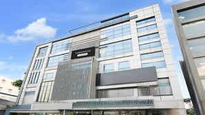 A modern building with a prominent 'TOWNHOUSE' sign, large windows, and a clean facade. - Elegant Stays at Vanasthalipuram Hyderabad (Hyderabad)