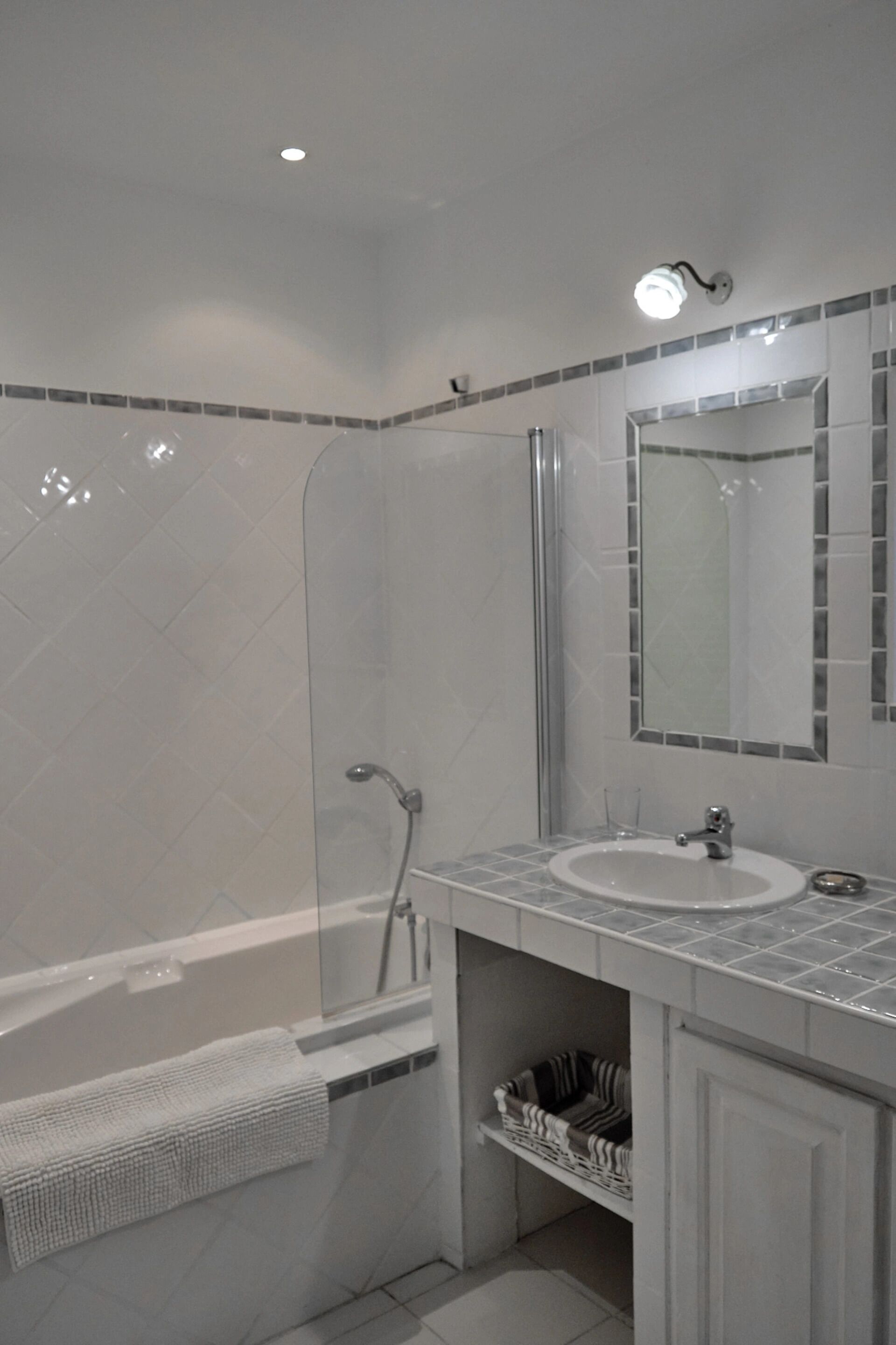 A modern bathroom with a bathtub, a sink, and a mirror.