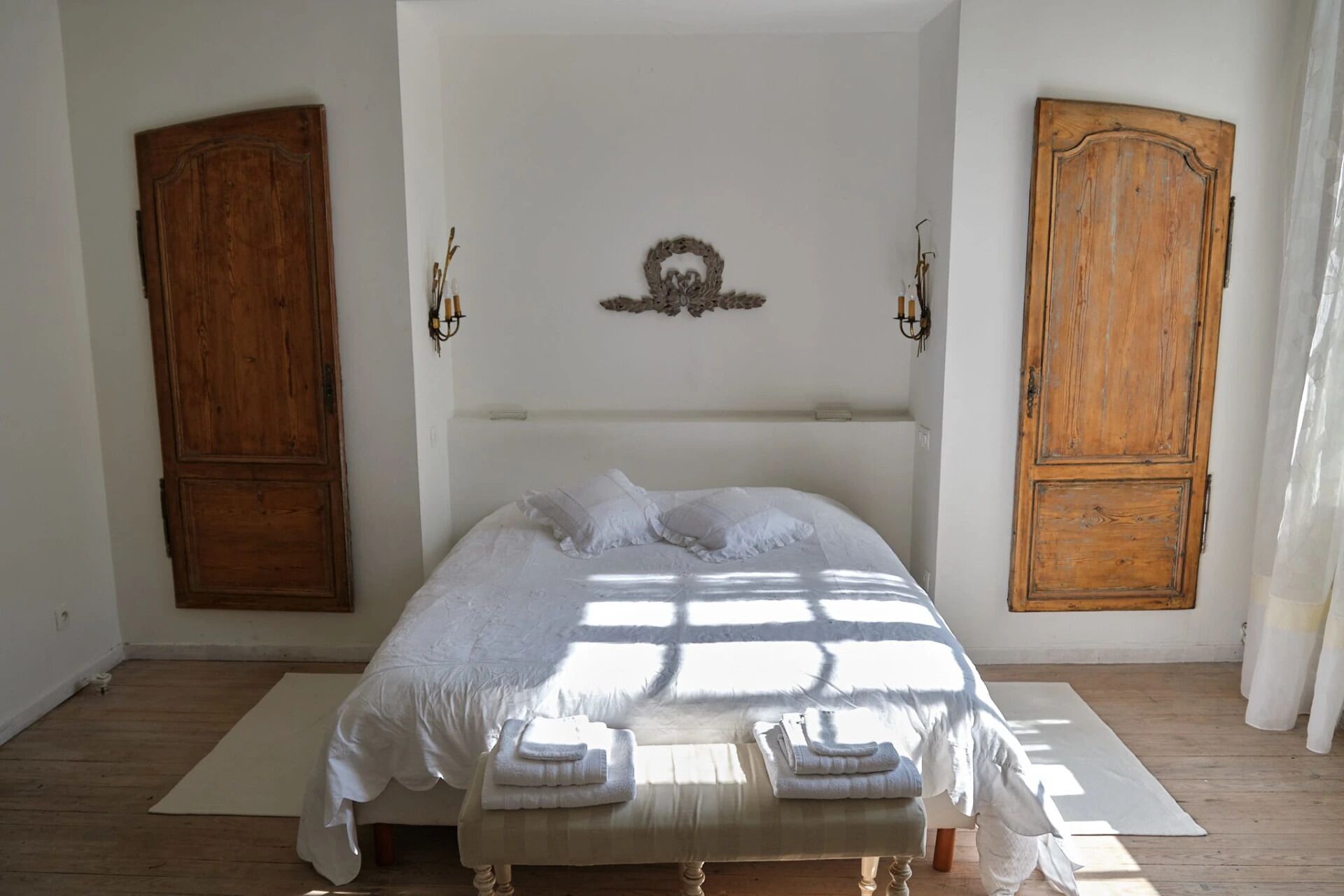 Un dormitorio con una cama grande, dos armarios de madera y un adorno en la pared.