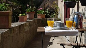 A table set outdoors with a pitcher, glasses, and a cup of orange juice. - L Ancien Couvent Cahuzac (Cahuzac)