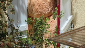 A large teddy bear positioned at a gate, with a white door and a red frame. - L Ancien Couvent Cahuzac (Cahuzac)
