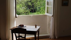 A room with a window overlooking a lush garden. - L Ancien Couvent Cahuzac (Cahuzac)