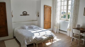 A bedroom with a large bed, a wooden wardrobe, a desk, and a chair. - L Ancien Couvent Cahuzac (Cahuzac)