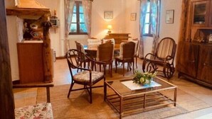A cozy living room with wooden furniture, a coffee table, and a fireplace. - Le Castel Blanc (Chatelblanc)
