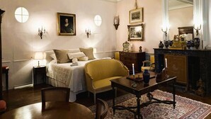 A bedroom with a bed, a chair, a table, a dresser, and a mirror. - Le Château D'Estrac (Hastingues)