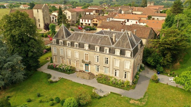 An aerial view of a historic building with a symmetrical facade, a central entrance with steps, and a surrounding well-maintained garden. - Le Château D'Estrac (Hastingues)