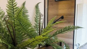 A wooden planter with ferns in a hallway.
