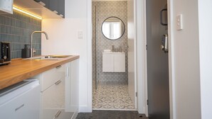 Eine moderne Küche mit einer Holzarbeitsplatte, eingebauten Geräten und einer gemusterten Spritzschutzwand.