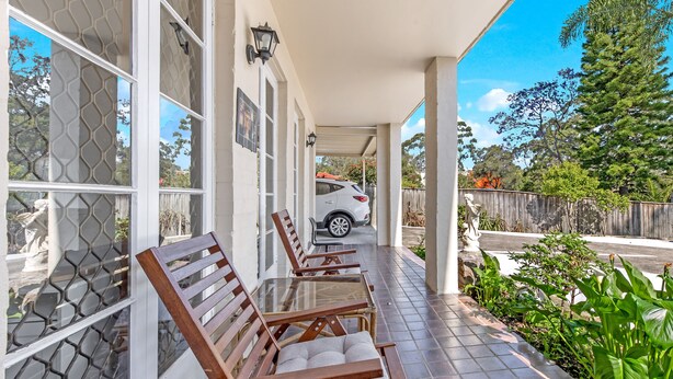 A covered patio with wooden chairs and a white car parked outside. - Kozyguru | Thornleigh | Townhouses (Thornleigh)