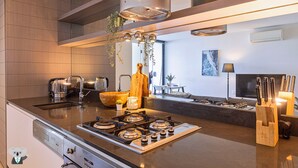 Una cocina moderna con estufa a gas, un lavabo y un cuenco de madera.