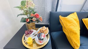 A breakfast tray with croissants, grapes, orange juice, and a protein drink on a gold tray. - Cosy and Comfy Deluxe Luxury Apartment close to the o2 Arena, Cutty Sack / Parks (London)