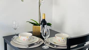 A table set with floral-patterned plates, a wine bottle, and two wine glasses.