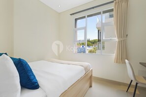 Une chambre à coucher avec un lit, une chaise et une fenêtre avec des rideaux.