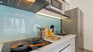 Een moderne keuken met een ingebouwde kookplaat, magnetron en een roestvrijstalen koelkast.