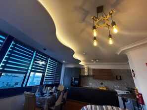 Una cucina moderna con soffitto curvo, elettrodomestici integrati e zona pranzo con tavolo e sedie.
