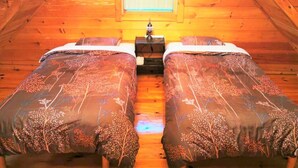 A wooden attic bedroom with two beds, a nightstand, and a window. - Private Log Cabin-Perfect for families, large groups, Parties are welcome! (Nasu-gun Nasu-machi)