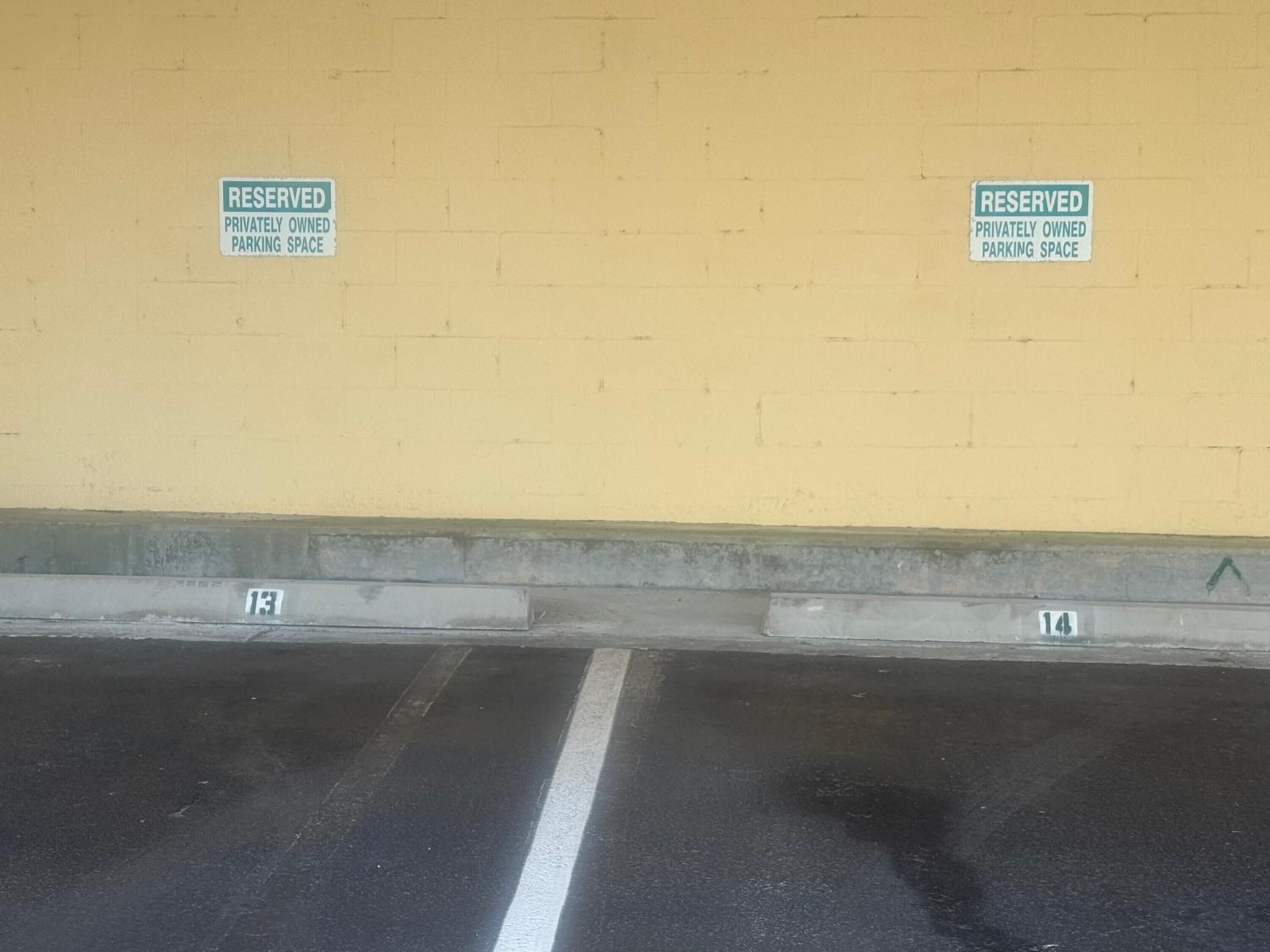 A parking area with two 'RESERVED' signs indicating privately owned parking spaces.