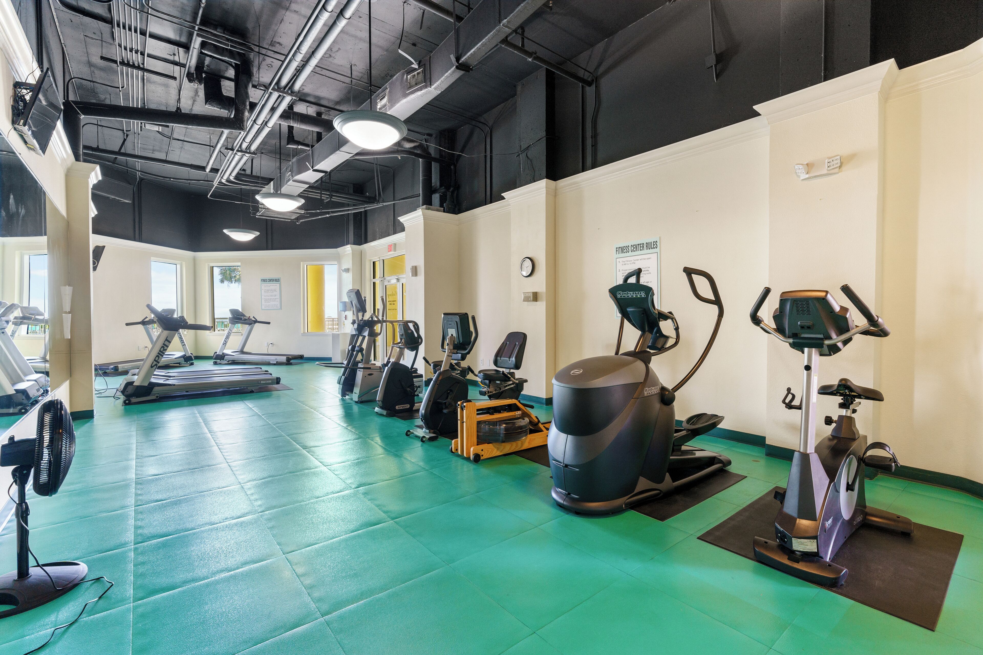A gym with treadmills, stationary bikes, and elliptical machines.