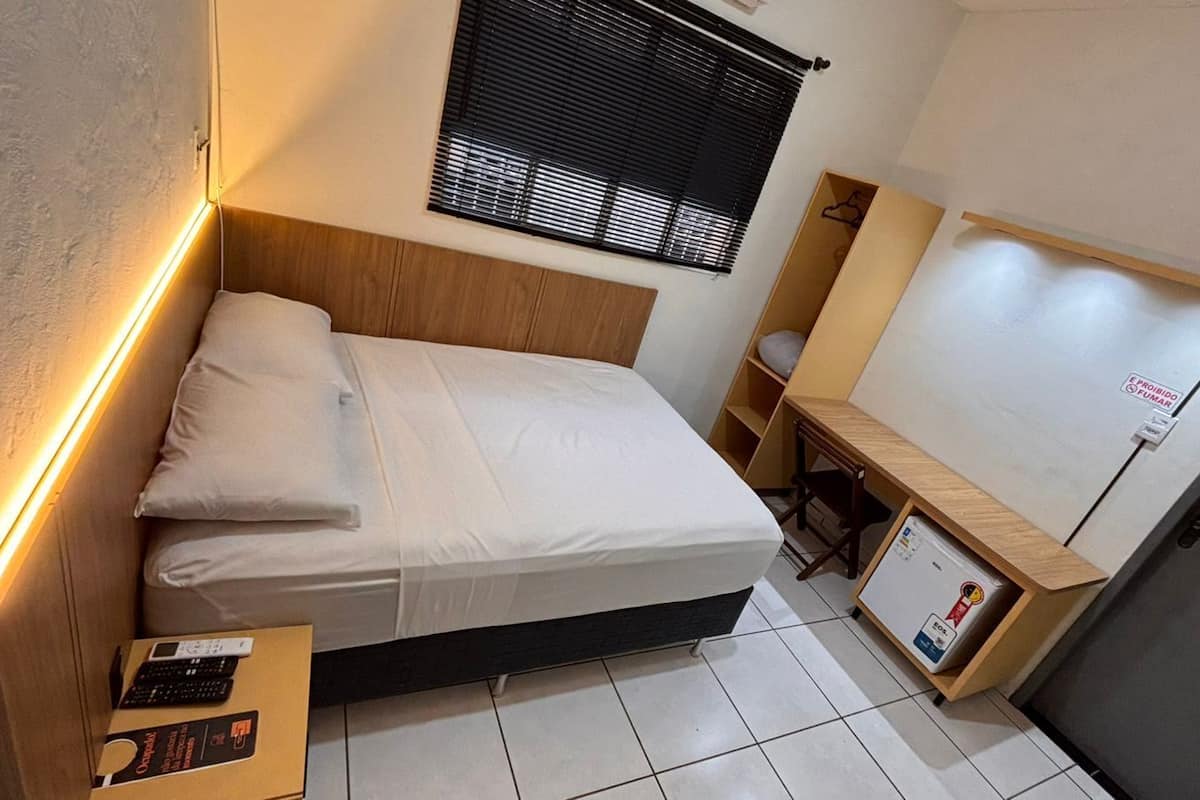 Ein gemütliches Schlafzimmer mit Bett, Nachttisch und einer kleinen Schreibtischzeile.