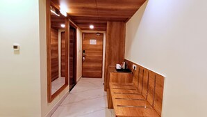 Un pasillo estrecho con paredes de madera y un banco a la derecha.