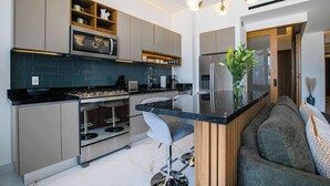 Cozinha moderna com eletrodomésticos integrados, uma ilha central e área de estar.