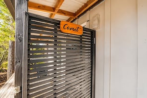 A wooden slatted gate with a sign that reads 'Comet.'