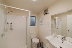 Moderni kylpyhuone, jossa on suihku, wc ja pesuallas.