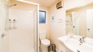 A bathroom with a shower, toilet, sink, and a window. - Orion | Lake Tekapo | Hot Tub | Sleeps 3 (Lake Tekapo)