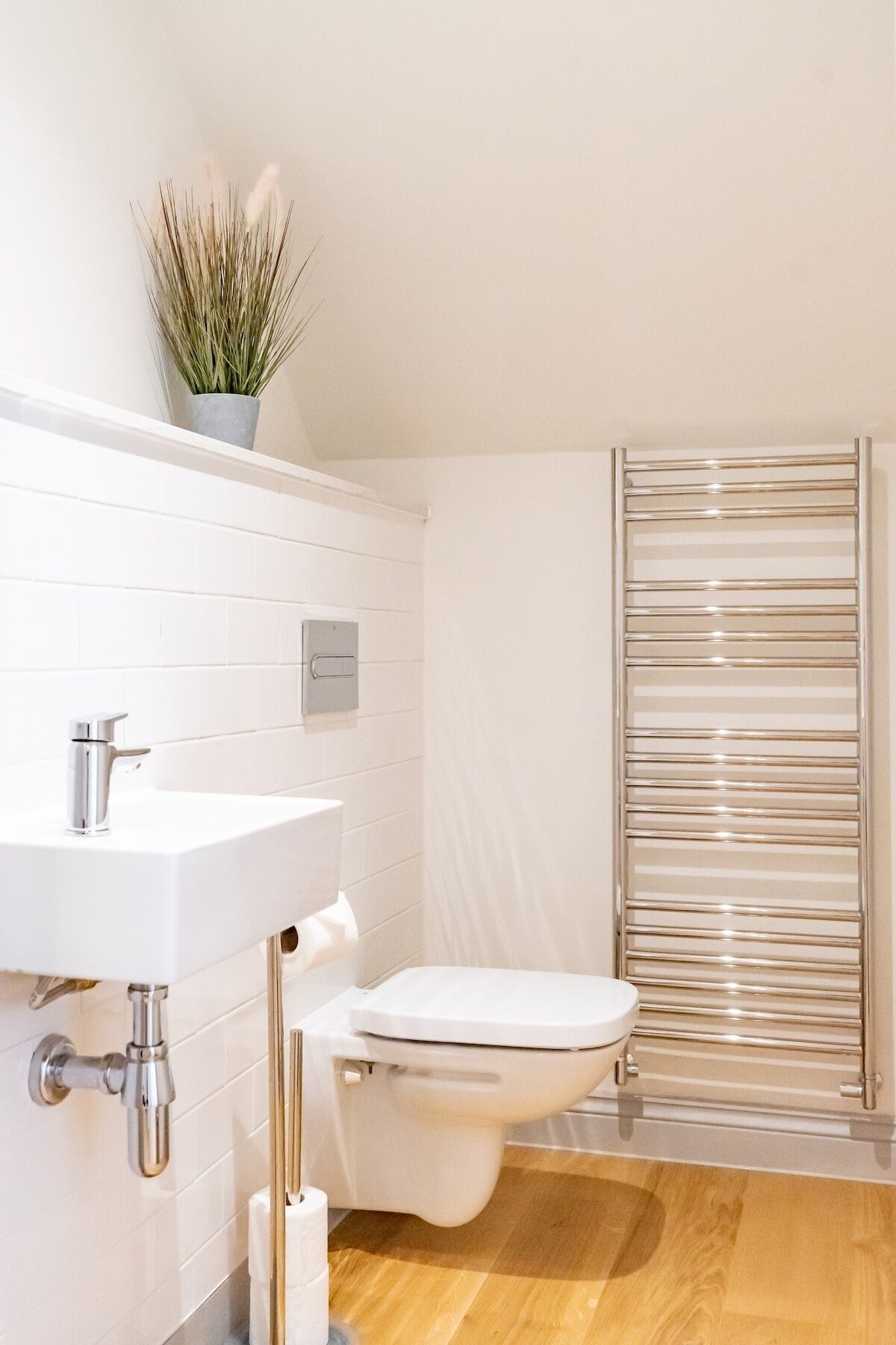 Ein modernes Badezimmer mit Waschbecken, Toilette und Handtuchheizkörper.