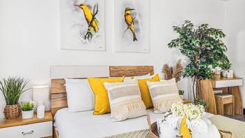Een slaapkamer met een bed, nachtkastje, lamp en decoratie aan de muur.