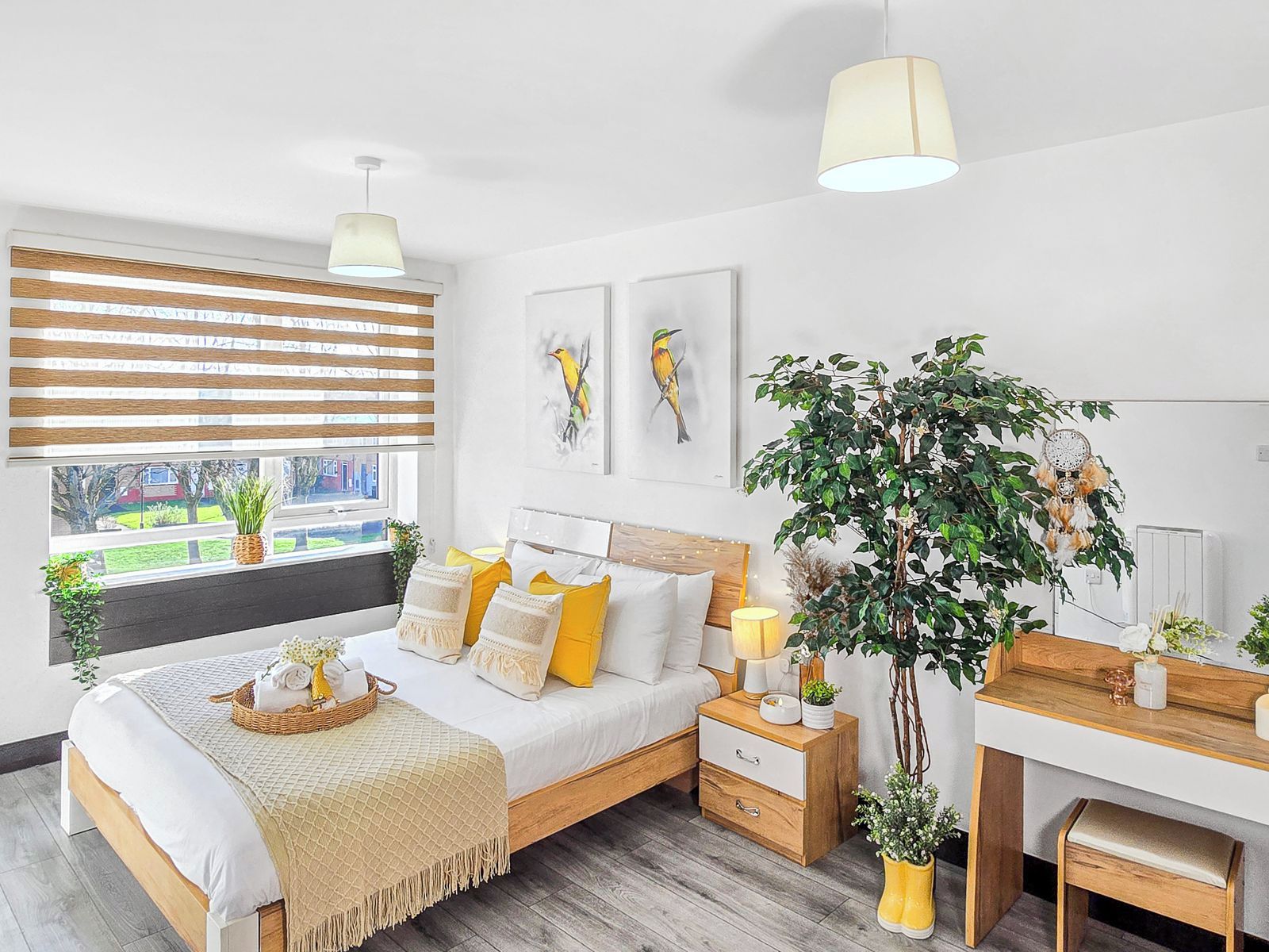 Ein modernes Schlafzimmer mit Bett, Nachttischen, einem Schreibtisch und einem großen Fenster mit Jalousien.
