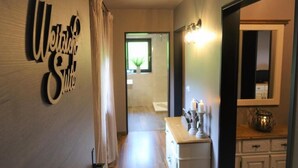 A hallway with a 'Welcome' sign, a mirror, a dresser, and a window with a plant. - Montara Suites Bodenmais (Bodenmais)