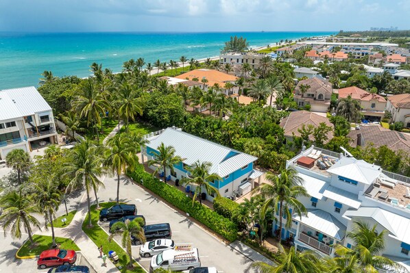 A coastal residential area with houses, palm trees, and a beach.