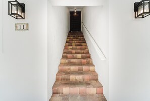 A staircase with a handrail, leading to a dark door at the top. - Designer Beachside Serenity– Steps to the Beach! (Juno Beach)
