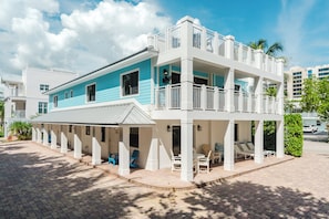A two-story building with a balcony and outdoor seating area. - Modern Lux Seaside | 100 Ft to Juno Beach (Juno Beach)