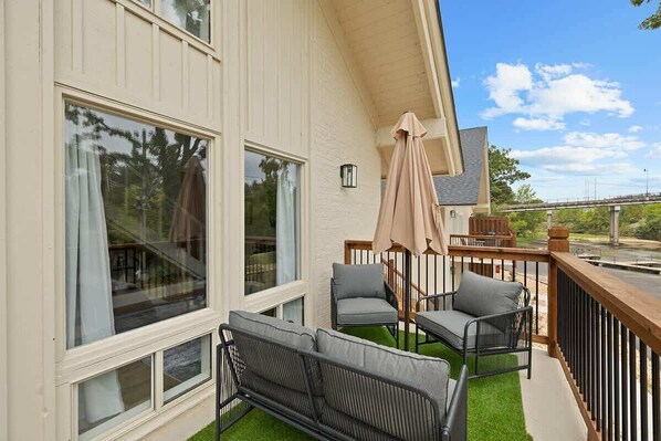 Un balcón con mobiliario exterior, una pérgola y vistas a la calle.