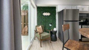 A modern kitchen with a green wall, a stainless steel refrigerator, and a dining table. - D4 Creekside Walk to Convention and The Landing (Branson)