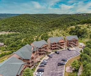 A lodge with multiple buildings, a parking lot, and a mountainous backdrop.
