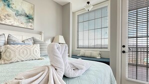 A bedroom with a bed, pillows, a blanket, a painting, and a window with blinds. - L-3 Stunning Views clean cozy close to SDC (Branson)