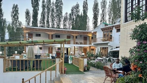 A hotel courtyard with outdoor seating, a staircase, and a garden area. - City Heart Boutique Stays (Leh)