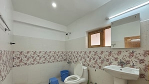 A bathroom with a toilet, sink, and shower. - City Heart Boutique Stays (Leh)