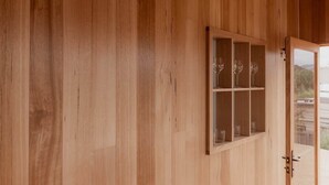 A wooden wall with a glass-fronted cabinet containing wine glasses. - 'Engineers Hut 1823' in Historic Richmond (Richmond)