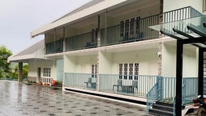 A two-story building with a covered balcony and a staircase leading to the upper floor. - Winter Garden Resorts (Munnar)