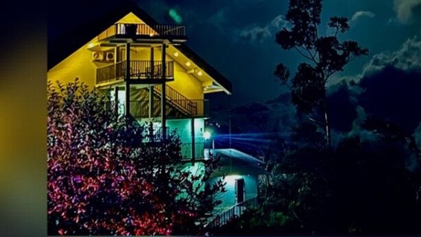 A two-story building with a balcony, surrounded by trees and illuminated by night lighting. - Winter Garden Resorts (Munnar)