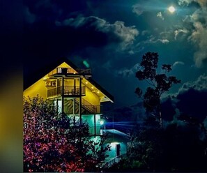 A two-story building with a balcony, surrounded by trees and illuminated by night lighting. - Winter Garden Resorts (Munnar)