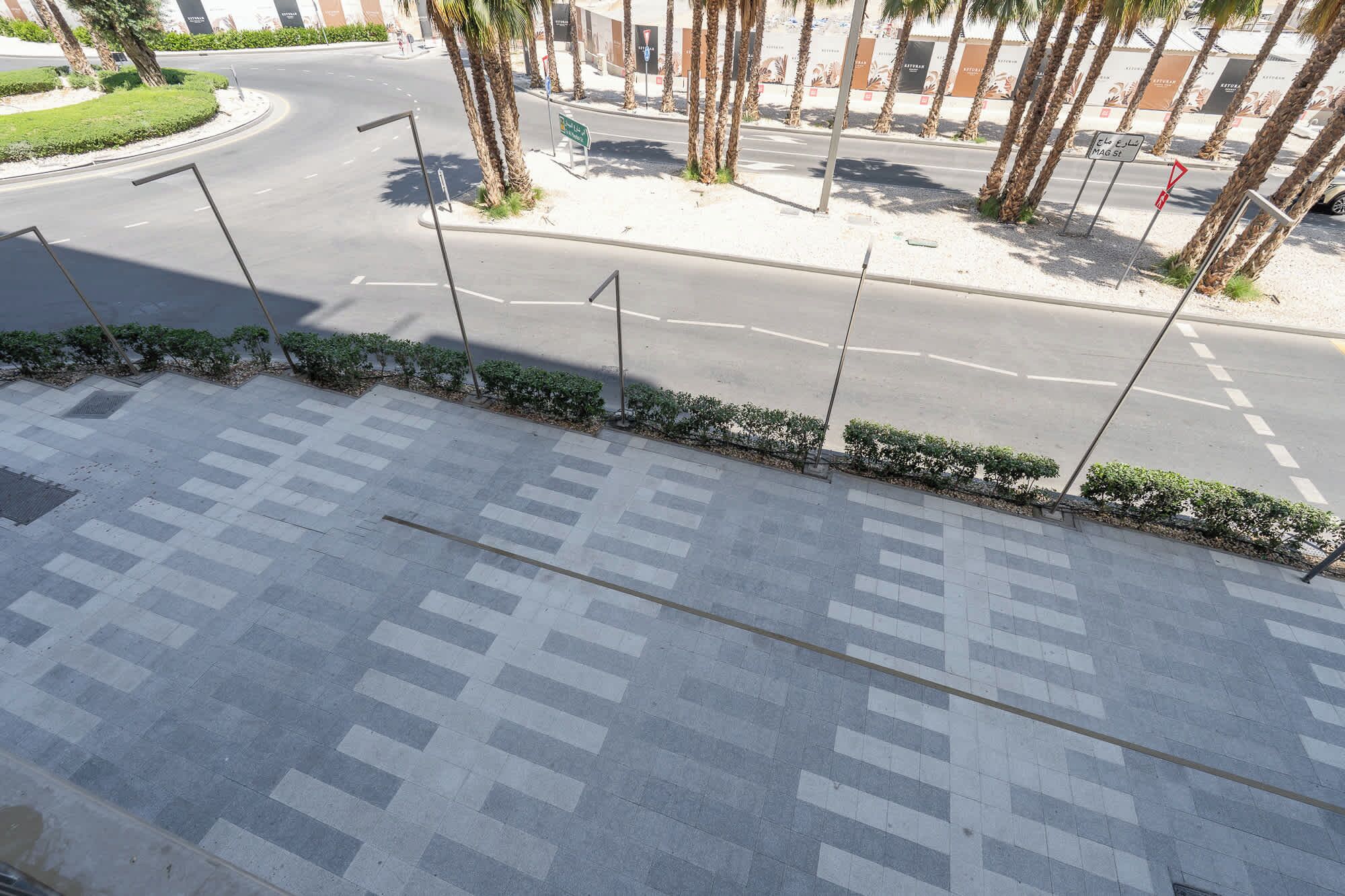 Un passage piéton avec un revêtement de sol à motifs et des palmiers.