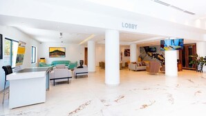A modern lobby with a reception desk, seating areas, and a TV screen. - Kigali Delight Hotel (Kigali)